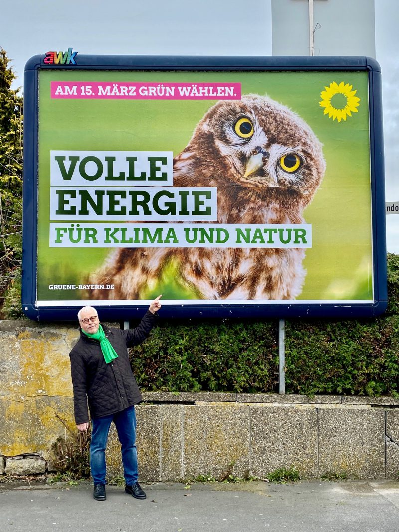Klaus Sanzenbacher vor Plakat der GRÜNEN zur Kommunalwahl in Kitzingen